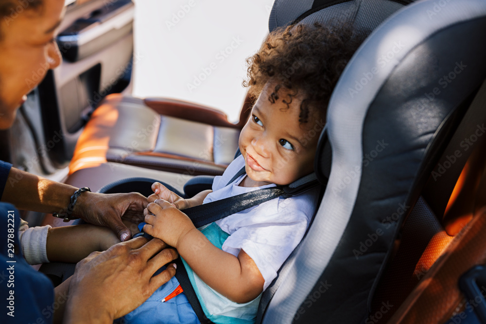 mom securing a car seat